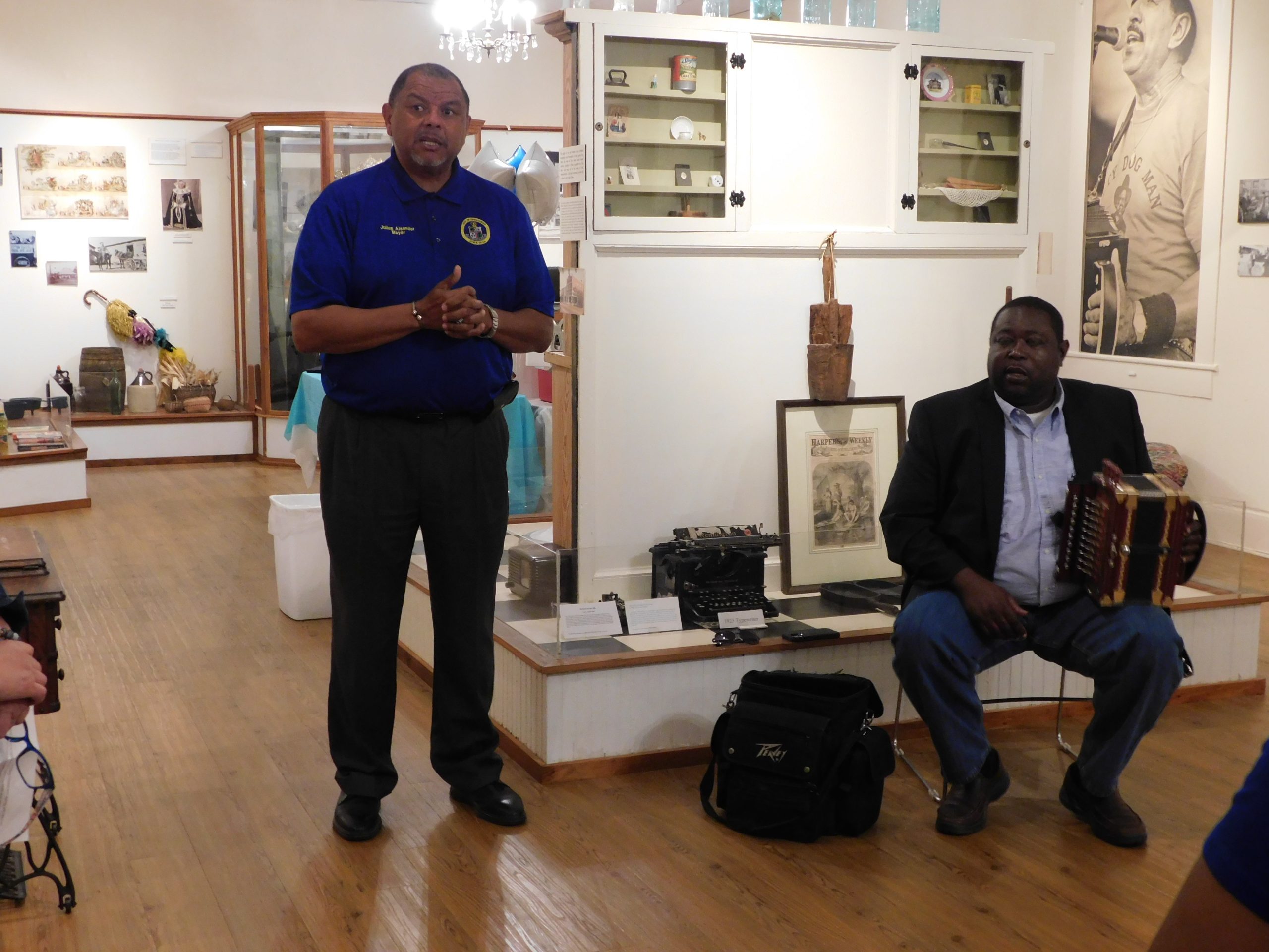 Mayor Julius Alsandor speaks at the museum. Accordionist Joe Hall in the background